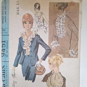 Pode incluir: Padrão de costura vintage para um vestido feminino com colarinho e punhos com babados. O padrão é da McCall's e é o número 9451. O padrão é para um tamanho único e é ajustável. O padrão é para um vestido com colarinho e punhos com babados. O padrão é da McCall's e é o número 9451. O padrão é para um tamanho único e é ajustável.