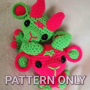 May include: Two handmade crochet creatures in neon green and pink. The creatures have large ears, black button eyes, and stitched details. The text "PATTERN ONLY" and "MTP Designs" are visible on the image.