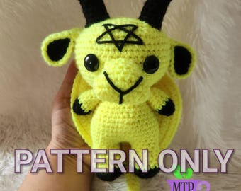 May include: Crochet pattern for a yellow amigurumi goat with black horns and a pentagram on its forehead. The pattern is called "PATTERN ONLY" and is by MTP Designs.