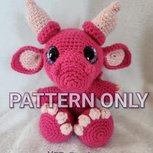 May include: Crochet pattern for a pink dragon amigurumi toy. The pattern includes instructions for making the dragon's body, head, horns, wings, and feet. The pattern is written in English and includes detailed instructions and photos.