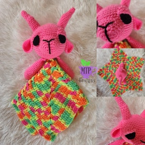 May include: A pink crocheted goat with black eyes and a multi-colored crocheted blanket. The blanket is a star shape with green, pink, orange, and yellow stripes. The blanket is made with a chevron stitch pattern. The goat is holding the blanket in its arms. The text "MTP Designs" is visible in the image.