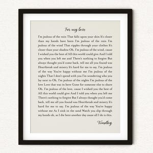 May include: A framed wall art print featuring the text For my love followed by lyrics starting with I'm jealous of the rain and ending with the name Timothy. The print has black text on a light beige background, enclosed in a thin black frame.