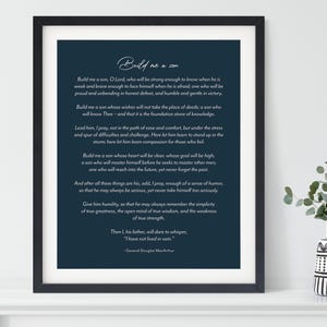May include: A framed print with a navy blue background and white text. The text is a poem titled "Build me a son." The black frame surrounds the print, which is displayed on a white shelf with a small vase.