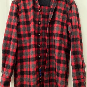 Op de afbeelding: Een rood, zwart en grijs geruit overhemd met knopen, een kraag en lange mouwen. De merknaam "Pendleton" is zichtbaar op de kraag.