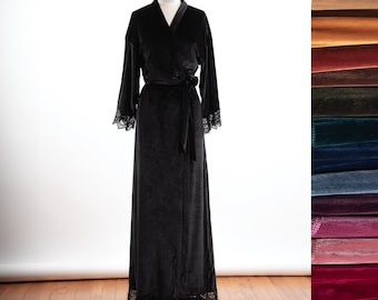 May include: A floor-length black velvet robe featuring long sleeves with black lace trim at the cuffs and hem, a V-neckline, and a matching fabric tie belt. A vertical color palette of various velvet fabric swatches is displayed on the right side.