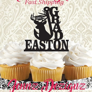May include: Black silhouette of a deer with a graduation cap and fishing hook with the word "GRAD" and the name "EASTON" underneath. The year "2017" is on the graduation cap. The image is on a white background with a black and white patterned border.