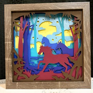 Arte enmarcado tridimensional hecho a mano de caballos corriendo en un bosque.