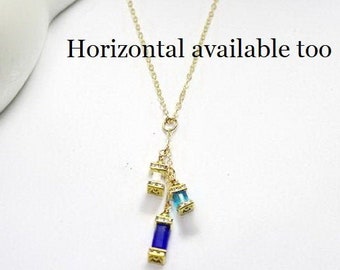 May include: A gold chain necklace with a pendant featuring three small, rectangular, faceted gemstones. The gemstones are blue, light blue, and clear. The text "Horizontal available too" is visible at the top of the image.