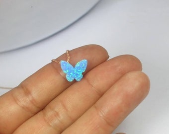 May include: A delicate gold chain necklace with a blue opal butterfly pendant. The butterfly is a popular symbol of hope, freedom, and transformation.