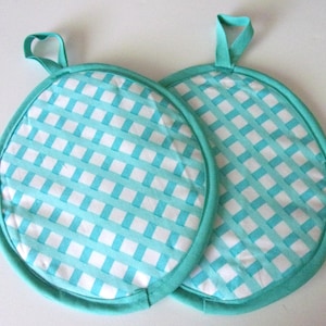 May include: Two turquoise and white gingham pot holders with a loop handle.
