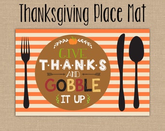Könnte beinhalten: Thanksgiving-Platzset mit orangefarbenen und cremefarbenen Streifen, mit einem braunen Kreis mit den Worten "GIVE THANKS AND GOBBLE IT UP". Schwarze Gabel-, Messer- und Löffelsilhouetten an den Seiten. Der Text "Thanksgiving Place Mat" steht oben.