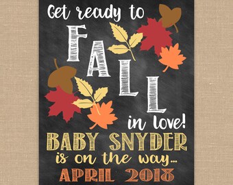 May include: Chalkboard style pregnancy announcement with autumn-themed graphics. The text reads "Get ready to fall in love! Baby Snyder is on the way... April 2018".