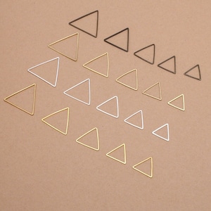 May include: Assortment of triangle-shaped metal hoops in various sizes. The hoops are in gold, silver, and bronze.