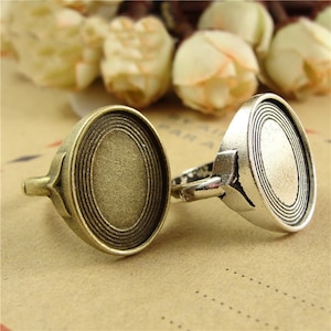 May include: Two silver-toned rings with a round, grooved design. The rings are made of metal and have a vintage look.