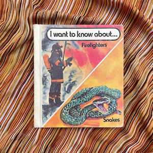 May include: A vintage children's book titled "I want to know about..." with illustrations of a firefighter and a snake. The book cover is divided diagonally, with the firefighter on the top half and the snake on the bottom half. The book cover is yellow, orange, and red.