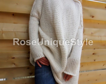 May include: A white oversized knitted sweater with a turtleneck collar. The sweater is made of a soft, fluffy yarn and has a relaxed fit.