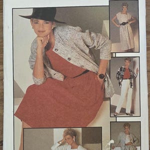 Może przedstawiać: Vintage koperta z wykrojem Simplicity, numer 6744, z kobietą prezentującą różne stroje. Na kopercie widnieje napis "Simplicity" w kolorze niebieskim. Rozmiar to 10, EUR 36. Stroje obejmują sukienkę, kurtkę i spodnie.