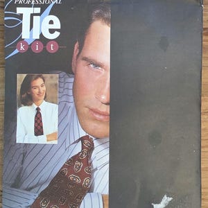 May include: A vintage "Professional Tie Kit" pattern cover. The cover shows a man wearing a patterned tie and a woman wearing a patterned tie in a smaller inset image. The text "Tie kit" is prominently displayed.