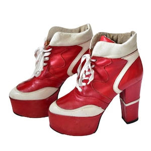 Peut inclure: Une paire de bottines à plateforme vintage rouges et blanches. Les bottines présentent une semelle plateforme haute, un design à lacets et un talon épais. Le cuir rouge est accentué de garnitures blanches et d'un col blanc.