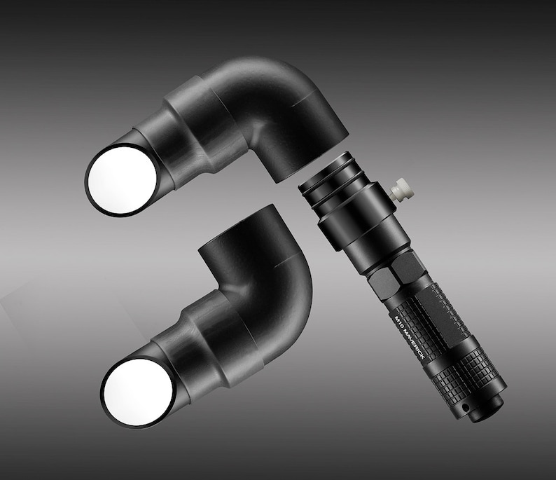 May include: Black flashlight with the text "M10 Maverick" and two black 90-degree elbow connectors with white circular openings. The flashlight is positioned between the connectors, suggesting a possible connection or assembly.