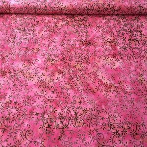 May include: Pink fabric with a brown swirl pattern. The fabric has a tie-dye effect.