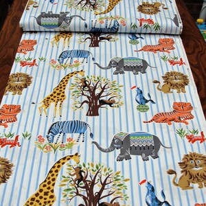 May include: Blue and white striped fabric with a repeating pattern of animals including elephants, giraffes, zebras, tigers, monkeys, and lions. The fabric is ideal for quilting, sewing, and crafting.