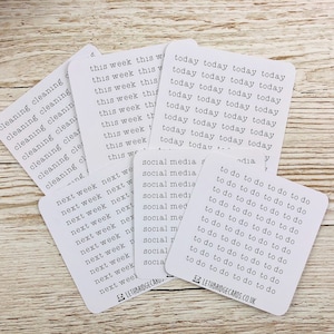 Puede incluir: Un conjunto de pegatinas blancas para planificadores con varias frases impresas en negro. Las frases incluyen "limpieza", "esta semana", "la próxima semana", "redes sociales" y "que hacer".