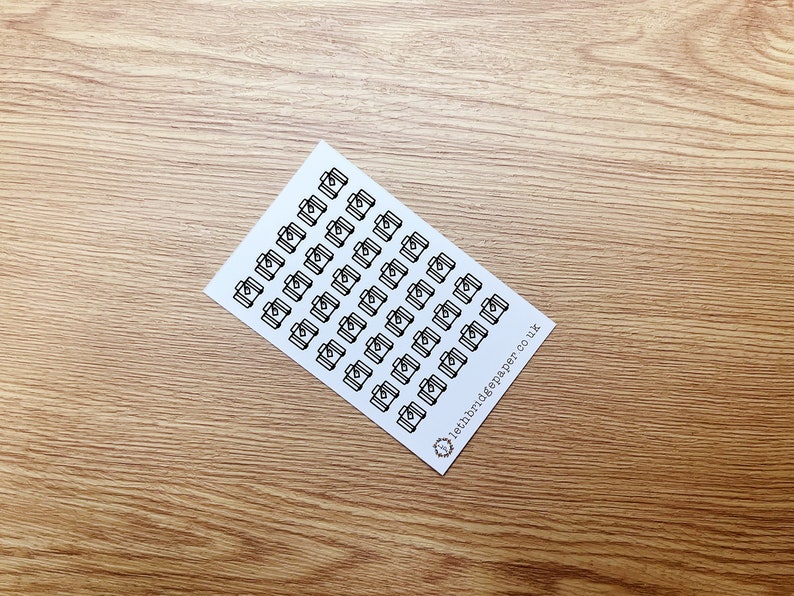 May include: A sheet of white paper with black camera icons printed on it. The sheet is folded in half and the text "leithbridgepaper.co.uk" is printed on the bottom right corner.