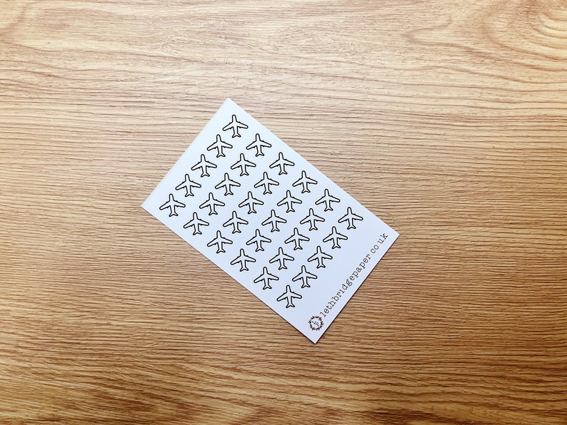 May include: A sheet of white paper with a repeating pattern of black airplane silhouettes. The paper has the text "lettr.digペーパー.co.uk" printed in the bottom right corner.