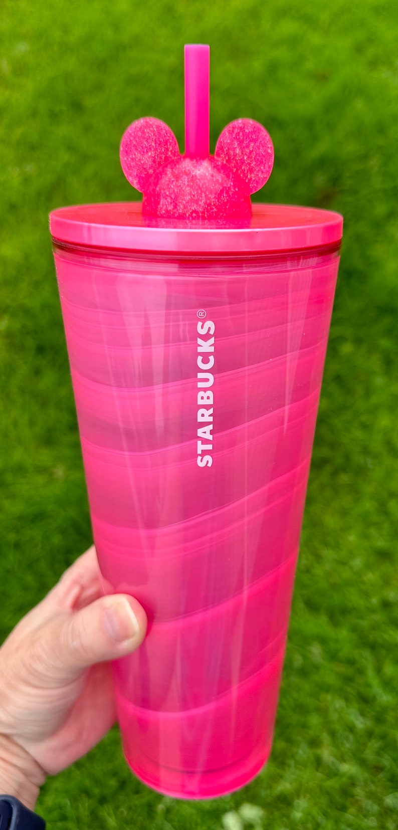 May include: A pink swirl tumbler with a Mickey Mouse lid and straw. The tumbler has the Starbucks logo on the side.