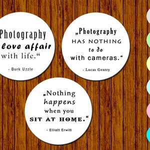 Könnte beinhalten: Drei weiße runde Untersetzer mit schwarzem Text auf einem Holzgrund. Die Untersetzer zeigen Zitate über Fotografie von Burk Uzzle, Lucas Gentry und Elliott Erwitt.