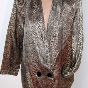 May include: A long-sleeved, gold and brown patterned satin blazer with a deep V-neck and two black buttons.