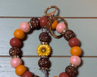 Floral brown fall leaves beaded wristlets keychain, with daisy keychain bar, and bling.  Bangle wristlets floral fall colors keychain