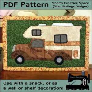 May include: A PDF pattern for a quilted camper van wall hanging. The camper is brown and beige with a green leafy background. The pattern is from Sher's Creative Space.