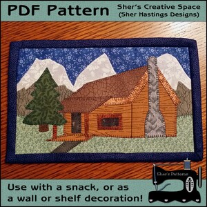 May include: A PDF pattern for a quilted cabin with a snowy mountain backdrop. The pattern is titled "Sher's Creative Space (Sher Hastings Designs)".