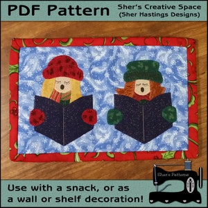 May include: PDF pattern for a Christmas-themed quilted wall hanging featuring two figures in red and green hats singing from a book. The background is a blue and white snowflake pattern. The text "Sher's Creative Space (Sher Hastings Designs)" is at the top of the image.