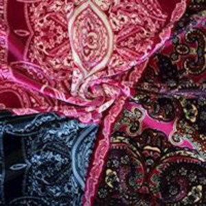 May include: A pink, black, and blue paisley patterned fabric with a white design. The fabric is soft and flowing.