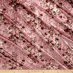 May include: Pink crushed velvet fabric with a floral print in shades of red, white, and green.