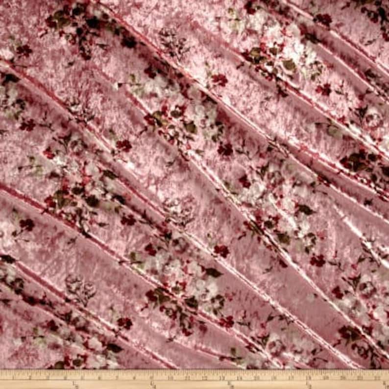 May include: Pink crushed velvet fabric with a floral print in shades of red, white, and green.