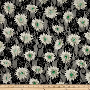 May include: Black lace fabric with a white floral pattern. The flowers have a green center.