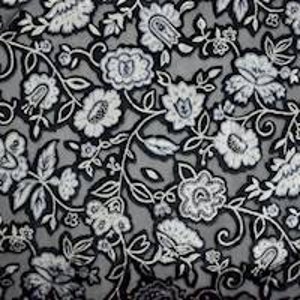 Op de afbeelding: Zwart-witte bloemenstof met een grijze achtergrond. De stof heeft een herhalend patroon van gestileerde bloemen en bladeren.
