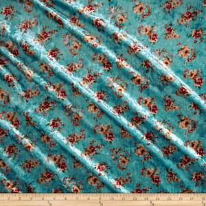 May include: Teal blue velvet fabric with a floral pattern in shades of pink and white.