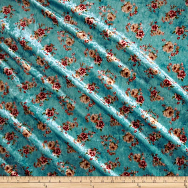 May include: Teal blue velvet fabric with a floral pattern in shades of pink and white.