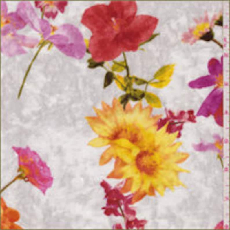 K&ouml;nnte beinhalten: Wei&szlig;er Stoff mit einem Blumendruck mit rosa, roten, gelben und gr&uuml;nen Blumen. Die Blumen sind &uuml;ber den Stoff verteilt und haben einen Aquarell-Effekt.