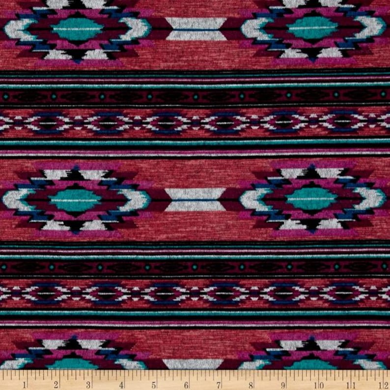 May include: Red fabric with a repeating pattern of turquoise, black, white, and pink geometric shapes. The fabric has a textured, woven look.