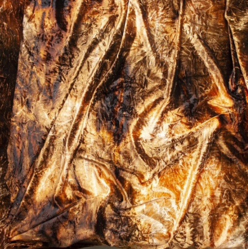 K&ouml;nnte beinhalten: Nahaufnahme eines goldenen, gekr&auml;uselten Samtstoffes mit einer strukturierten, zerknitterten Oberfl&auml;che.