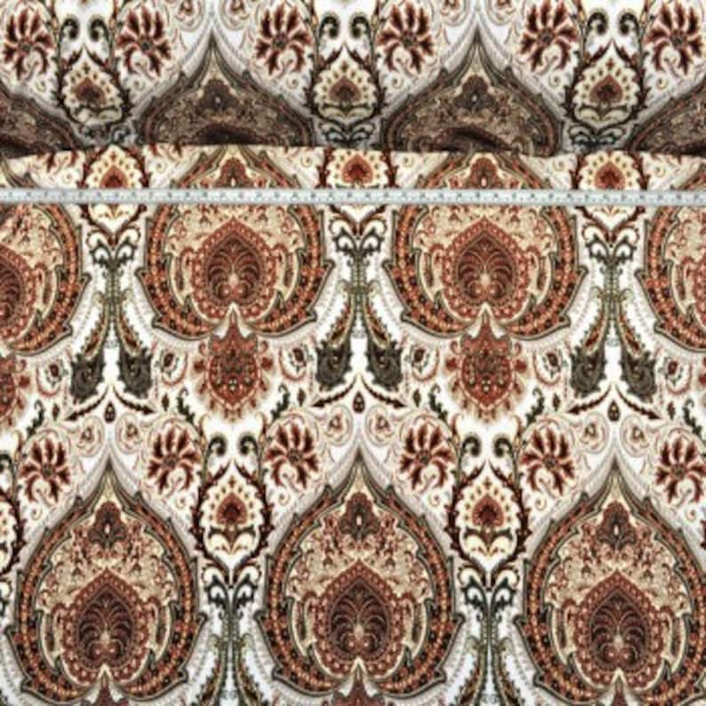 May include: White fabric with a brown, red, and gold paisley pattern.