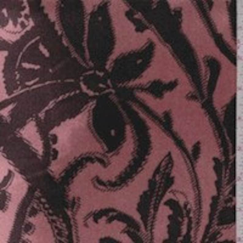 Puede incluir: Tela rosa con un patr&oacute;n floral negro. El patr&oacute;n presenta flores y hojas grandes y estilizadas.