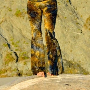 K&ouml;nnte beinhalten: Eine weite, ausgestellte Hose in einem Batik-Muster mit Gelb-, Braun- und Blaut&ouml;nen.