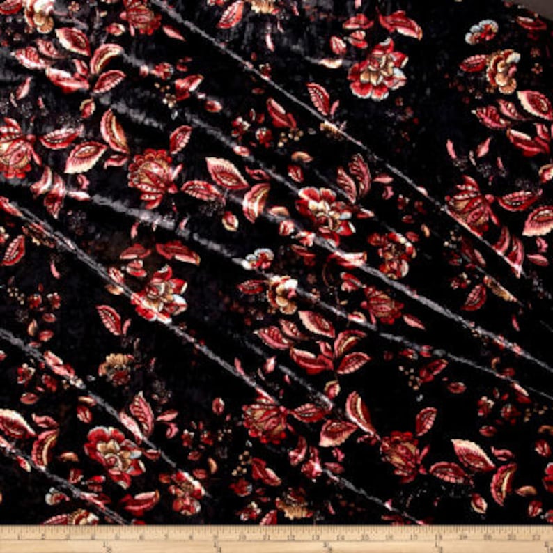 K&ouml;nnte beinhalten: Schwarzer Samtstoff mit einem floralen Muster in Rot- und Goldt&ouml;nen. Der Stoff ist weich, luxuri&ouml;s und perfekt f&uuml;r Polster, Vorh&auml;nge oder Kleidung.